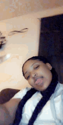 a woman is sitting on a couch with her tongue sticking out .