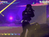 a man singing into a microphone with the words lalalalala on the bottom right