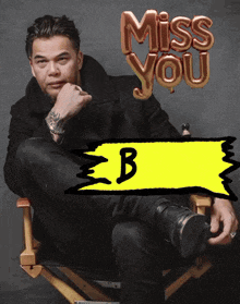 a man is sitting in a chair with a miss you balloon behind him