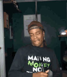 a man wearing a sweatshirt that says making money not friends
