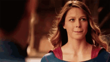 a woman in a superhero costume is making a funny face while standing next to a man .