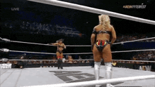 a woman is standing in a wrestling ring with a referee .