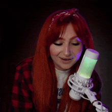 a woman with red hair stands in front of a microphone