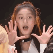 a close up of a woman making a funny face with her hands in the air .