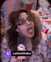 a woman with curly hair and glasses is singing into a microphone with the name latinaotaku on it