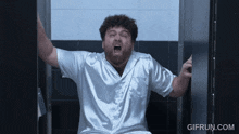 a man in a white shirt is screaming in a bathroom with gifrun.com at the bottom of the screen