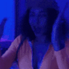 a woman is dancing in a dark room with blue lights .