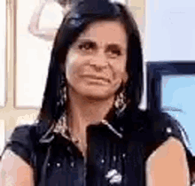 a woman is making a funny face while sitting in front of a tv .