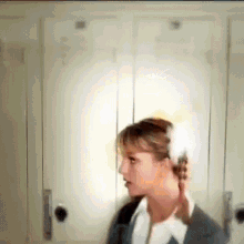 a woman in a suit and tie is standing in front of a row of lockers .