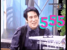 a man sitting in front of a sign that says 555 on it