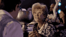 an older woman wearing glasses talks to a younger man