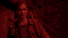 a woman is standing in a dark room in a video game in a red light .