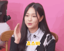 a girl with long black hair is wearing a black cardigan and a white shirt with chinese writing on it