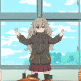 a girl is standing in front of a window with her arms outstretched in a classroom .