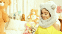 a girl wearing a teddy bear hat is smiling
