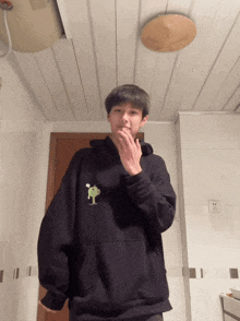 a person in a black hoodie with a frog on it