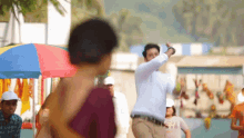 a man in a white shirt is dancing in a crowded street