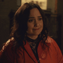 a woman wearing a red jacket and a black shirt with a leopard print