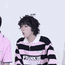a person wearing a pink and black striped shirt that says frankie rugby on it