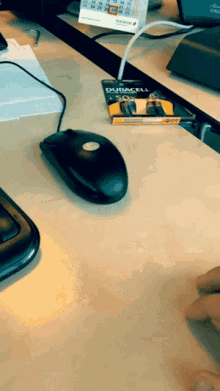 a pack of duracell batteries sits on a desk next to a mouse