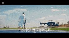 a man in a bathrobe stands in front of a helicopter with a foreign language caption