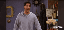a man is standing in front of a purple door with a lamp and flowers in front of him and the words imgplay below him