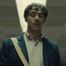 a man wearing a blue jacket and a white shirt is smiling