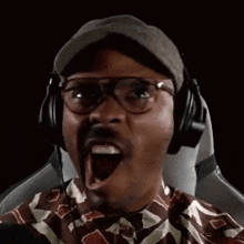 a man wearing glasses and headphones is making a funny face .