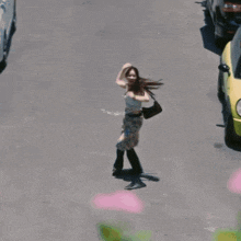 a woman is dancing in front of a yellow mini