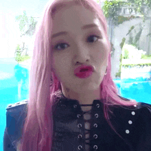 a woman with pink hair is making a face
