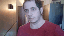 a man wearing a red shirt that says ' gnc ' on it