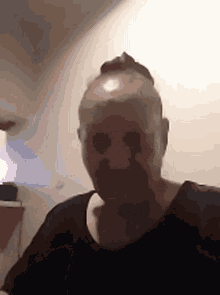 a man with a bald head is looking at the camera .