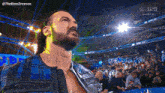 a man with a beard is standing in front of a crowd at a wrestling show