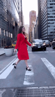 a woman in a red coat crosses the street