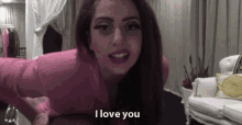 a woman in a pink dress is saying i love you .