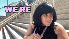 a woman standing in front of stairs with the words we 're above her head