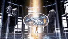 a man singing into a microphone with the indonesian idol logo behind him