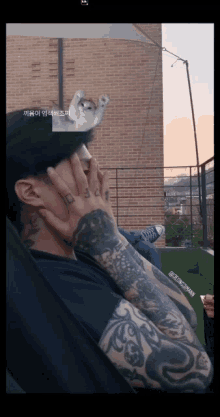 a man with a crown on his head has a tattoo that says ' a ' on it