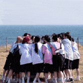 a group of girls are standing in a circle with one wearing a pink shirt that says ' i love you '