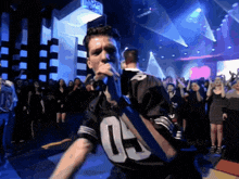 a man is singing into a microphone wearing a jersey with the number 6 on it