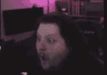 a blurry picture of a person 's face with their mouth open in a dark room .