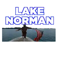 a man on a boat holding an american flag in front of the words lake norman