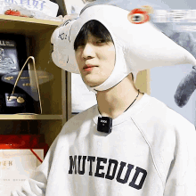 a young man wearing a white hat and a white shirt that says mutedud