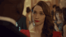 a woman in a red dress is looking at a man