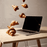 croissants are falling in front of a laptop