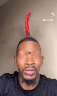 a man taking a selfie with a red scarf on his head