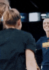 a group of women are dancing together in a dark room .