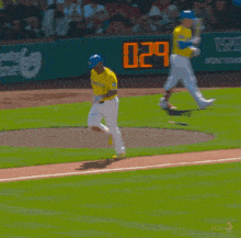 a baseball player wearing a yellow jersey that says boston is running on the field
