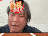 a man giving a thumbs up with the word good on his head