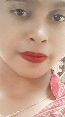 a close up of a young girl 's face with red lipstick .